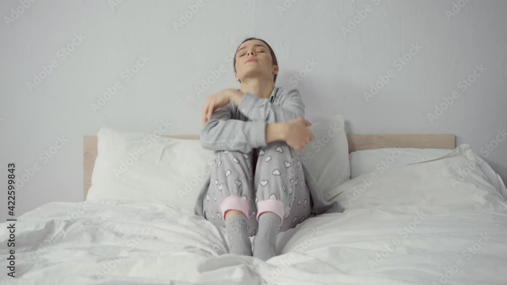 frustrated woman in pajamas sitting on bed frustrated woman in pajamas sitting on bed
