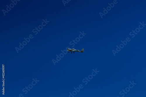 The plane flies in the blue sky