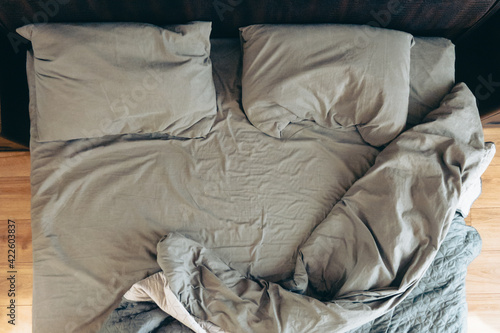 Slika na platnu top view of messy bed with gray sheets