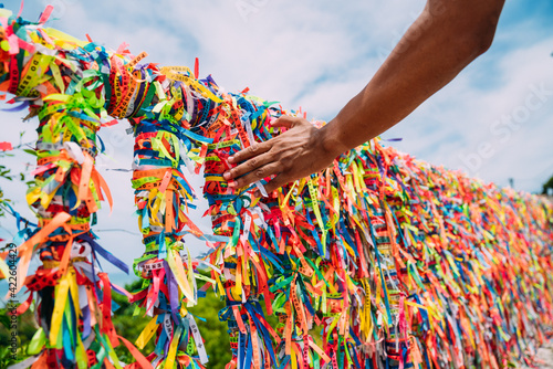 Closeup of colorful ribbons in Arraial D'Ajuda, Bahia, Brazil. Man hand making an order with Brazilian ribbons