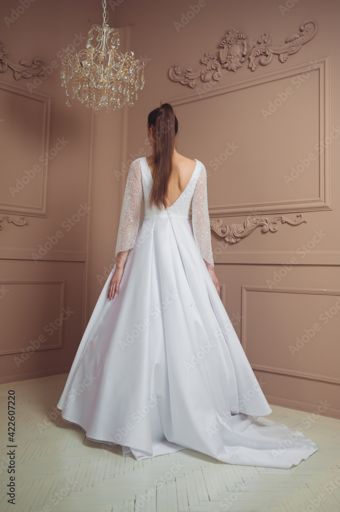 Beautiful fashion young bride in beige studioo interior before wedding ceremony in church Beautiful fashion young bride in beige studioo interior before wedding ceremony in church