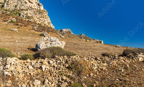 Landscape with rocky ground, rock, wall and house. Sicily