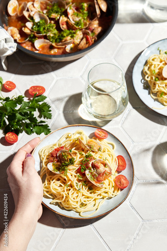 Mediterranean cuisine: pasta with seafood, with vongole. Italian lunch. Lifestal mood. Light background, top view photo