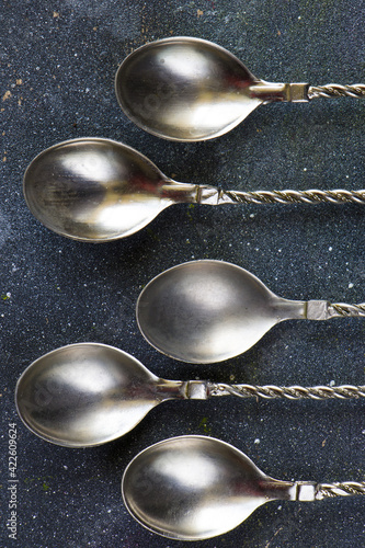 Vertical shot of ilver vintage spoon set on blue background photo