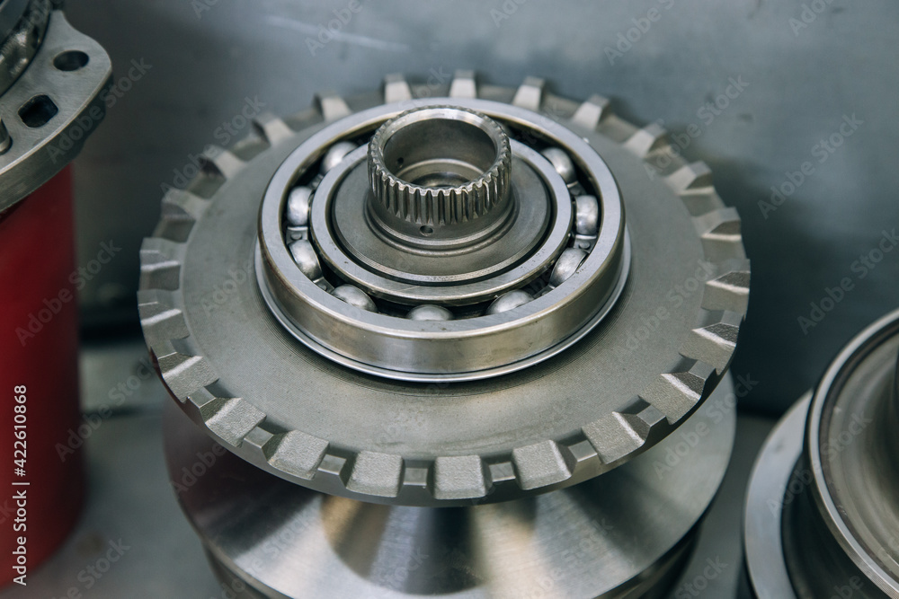 Set of various engine and gearbox spare parts. Shiny gears for planetary gearbox.Metal autotechnology background. wheel engine gears, close up. Automatic transmission in section Set of various engine and gearbox spare parts. Shiny gears for planetary gearbox.Metal autotechnology background. wheel engine gears, close up. Automatic transmission in section