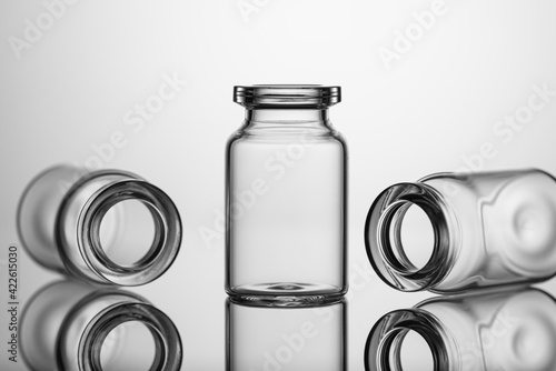 Medicine glass jars, capacity for liquid medicines with an open neck without stopper. Close up shot on a gray background