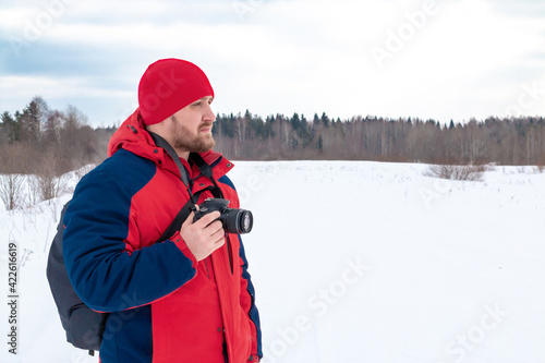 Photographer on a winter landscape with a camera in his hands.