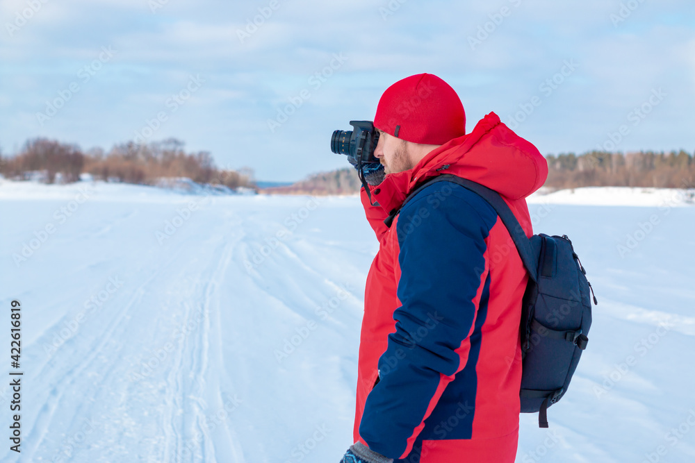 Photographer on a winter landscape with a camera in his hands.