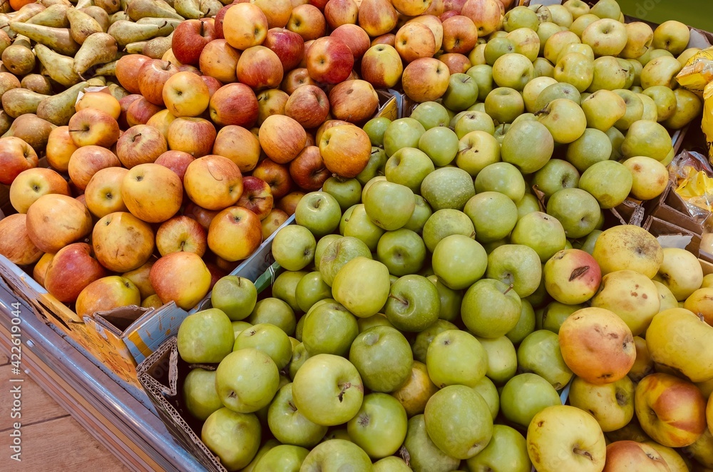 Ripe apples in a box. Fresh green and red apples on the counter in the supermarket Ripe apples in a box. Fresh green and red apples on the counter in the supermarket