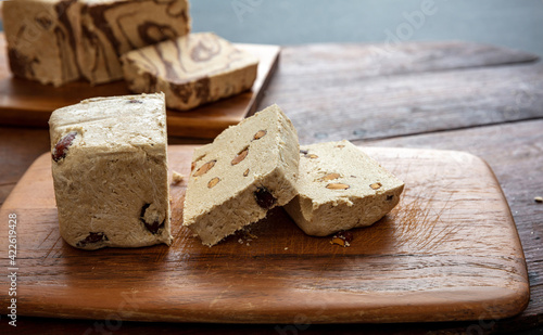 Halva almond nuts slices on wooden table background