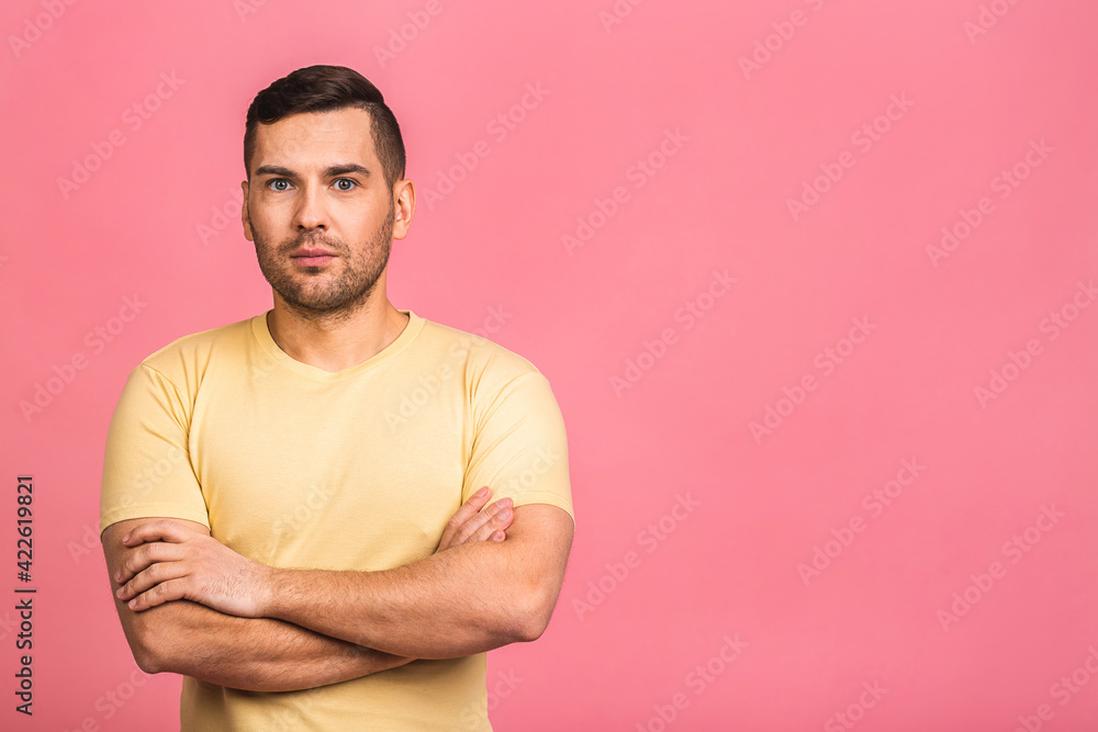 Portrait with copy space, empty place of stunning, sexy, smiling, cool man in casual having his arms crossed, looking at camera, isolated on pink background. Portrait with copy space, empty place of stunning, sexy, smiling, cool man in casual having his arms crossed, looking at camera, isolated on pink background.