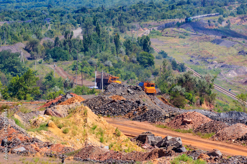 Heavy trucks working in the iron ore quarry