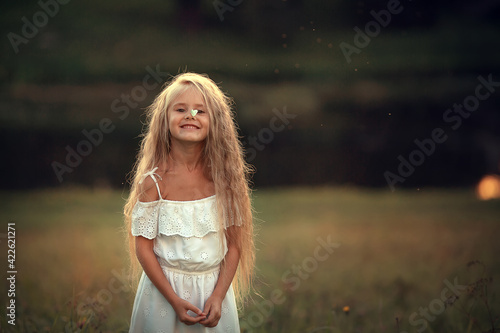 A butterfly is sitting on a nose of beautiful long-haired girl. Image with selective focus and toning