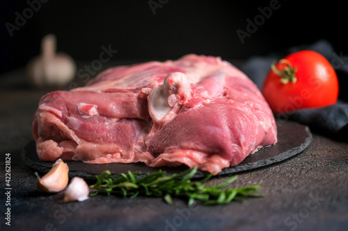 Fresh poultry meat. Turkey thigh with herbs on a dark background.