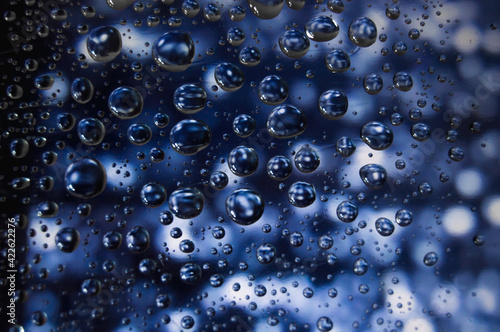 Surrealistic falling raindrops with blue unfocused background