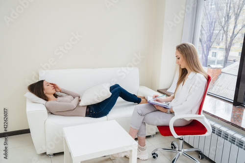 A young girl during depression communicates with a psychologist in the office. Psychological help.