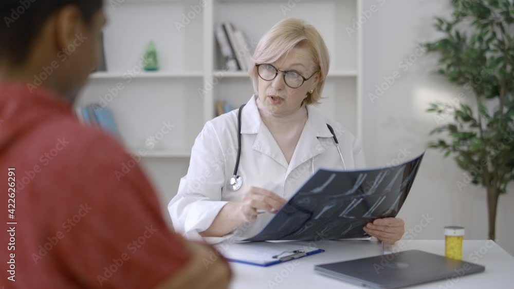 Trauma doctor checking patients x-ray image, successful bone fracture treatment Trauma doctor checking patients x-ray image, successful bone fracture treatment