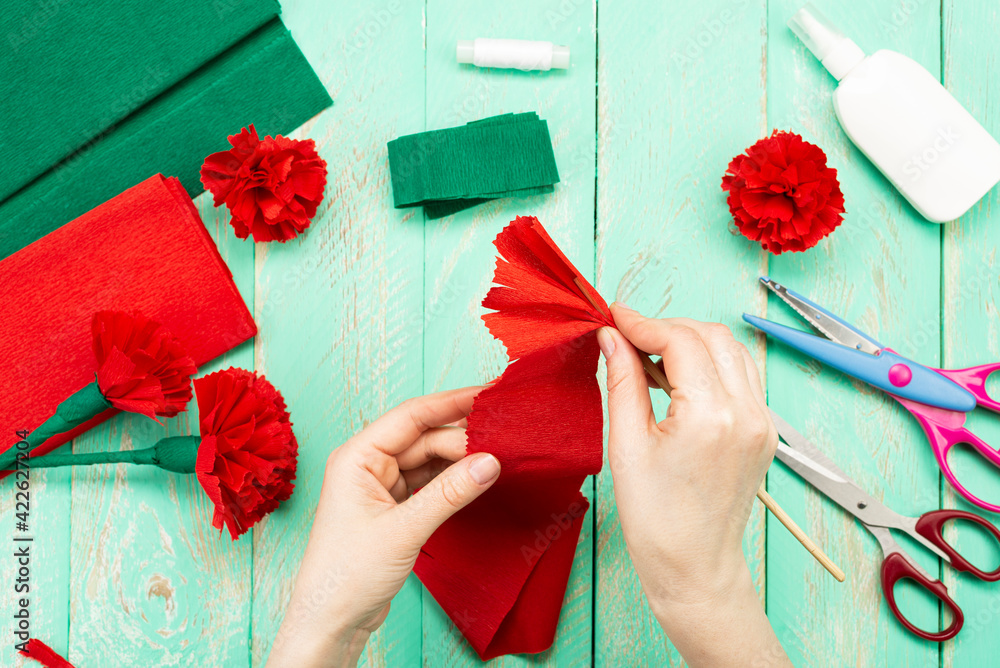 How to make a carnation flower at home. Hands make a red carnation