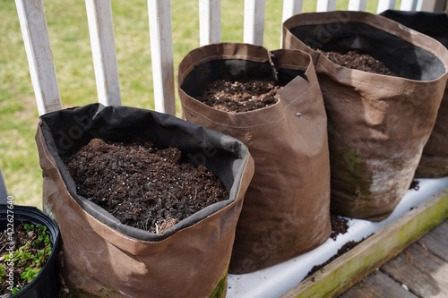 Homemade DIY grow bag filled with fresh mulch on backyard deck, selective focus