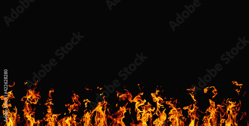 Burning banner. Flame design. Barbecue heat. Bright orange yellow hot fire glow with sparks isolated on black night abstract copy space background.