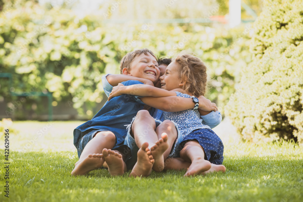 Playful siblings having fun on a green lawn