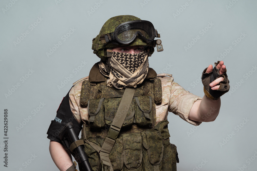 Fotka „Russian military police soldier in desert uniform. Patch on the  shoulder flag of Russia, arms of Russian army and the inscription Military  Police in Russian. Shot in studio on a grey