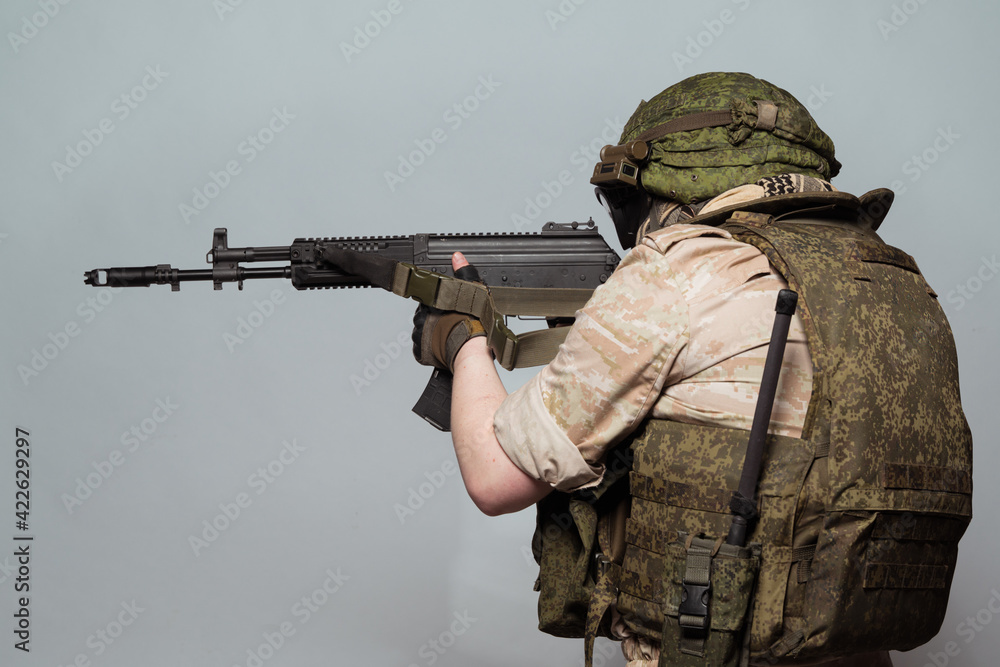 Russian military police soldier in desert uniform. Patch on the shoulder flag of Russia, arms of Russian army and the inscription Military Police in Russian. Shot in studio on a grey background. Russian military police soldier in desert uniform. Patch on the shoulder flag of Russia, arms of Russian army and the inscription Military Police in Russian. Shot in studio on a grey background.