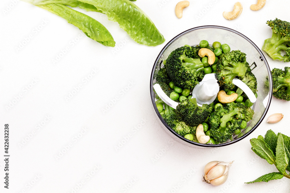 Green peas, broccoli and cashew nuts in blender bowl. Green peas, broccoli and cashew nuts in blender bowl.