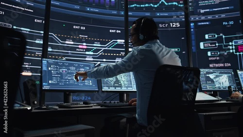 Professional IT Technical Support Specialists and Software Programmer Working on Computers in Monitoring Control Room with Digital Screens with Server Data, Blockchain Network and Surveillance Maps