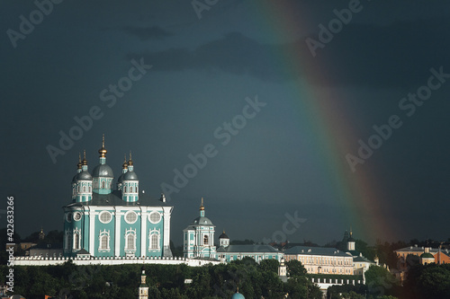 the rainbow and the church. the urban landscape of the old town after the rain. through the clouds you can see a bright rainbow against the background of houses