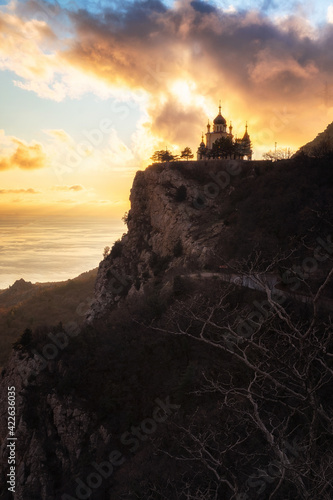 Epic high mountain church scenery view. Beautiful landscape at sunset. Colorful clouds