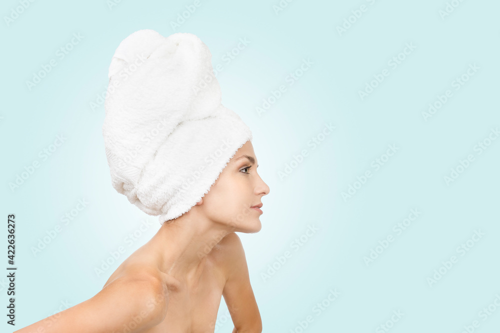 pretty girl in profile with rolled towel on her head on white background and copy space. pretty girl in profile with rolled towel on her head on white background and copy space.