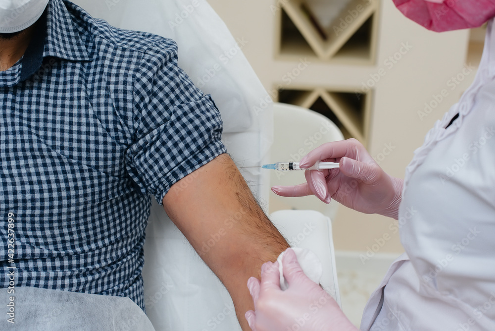 Vaccination of a man against flu and coronavirus infection during a worldwide pandemic. The formation of the immune system and antibodies. Vaccination of a man against flu and coronavirus infection during a worldwide pandemic. The formation of the immune system and antibodies.