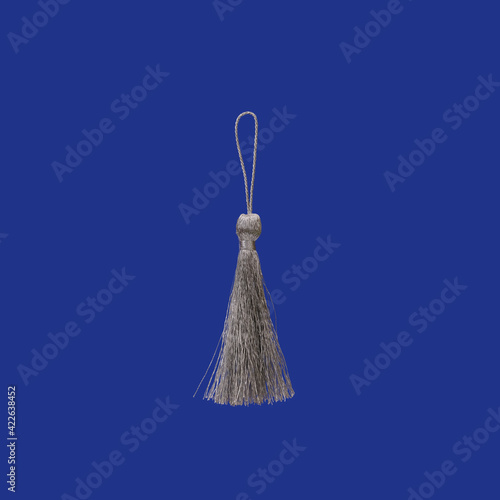 Silver silk tassel isolated on blue background for creating graphic concepts