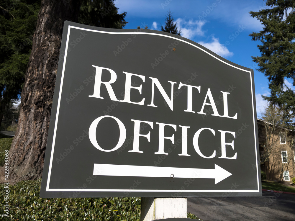 view of a sign pointing out the direction of an apartment rental office in a large community
