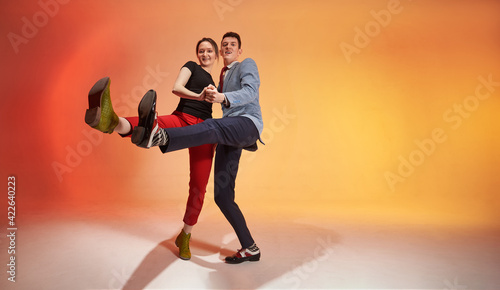 Young nice dancing pair in motion kicks to the camera