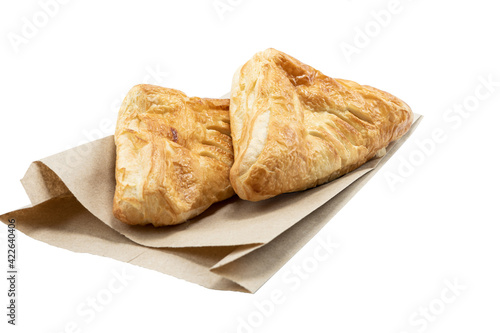 Homemade appetizing puff pastry pies on a paper bag