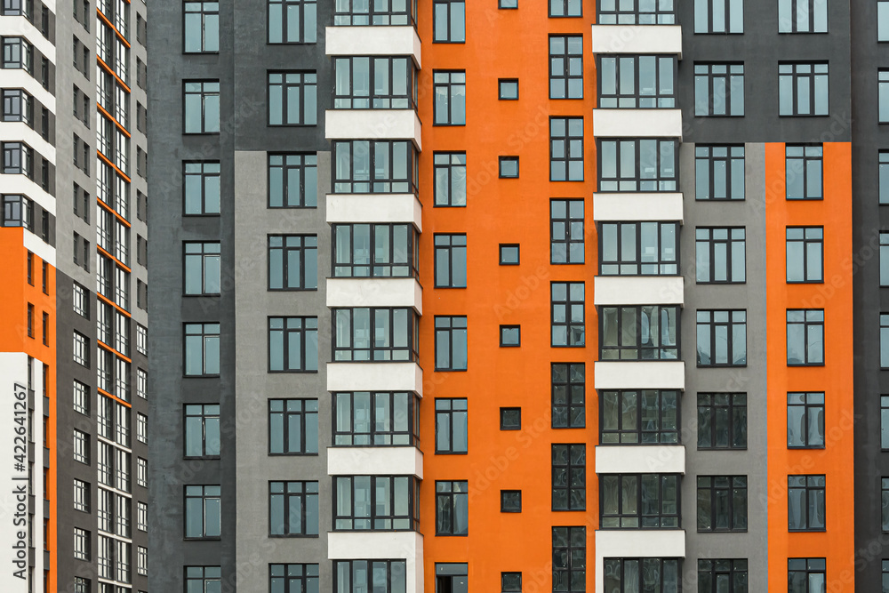 The facade of a multi-storey building with windows and balconies as an element of the architecture of a modern city The facade of a multi-storey building with windows and balconies as an element of the architecture of a modern city