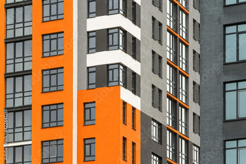 The facade of a multi-storey building with windows and balconies as an element of the architecture of a modern city