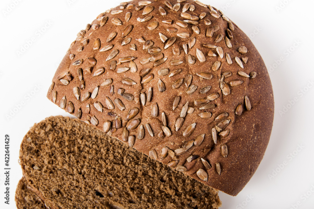 whole grain bread with seeds sliced on the wooden cutting board. white background. top view. close-up view whole grain bread with seeds sliced on the wooden cutting board. white background. top view. close-up view