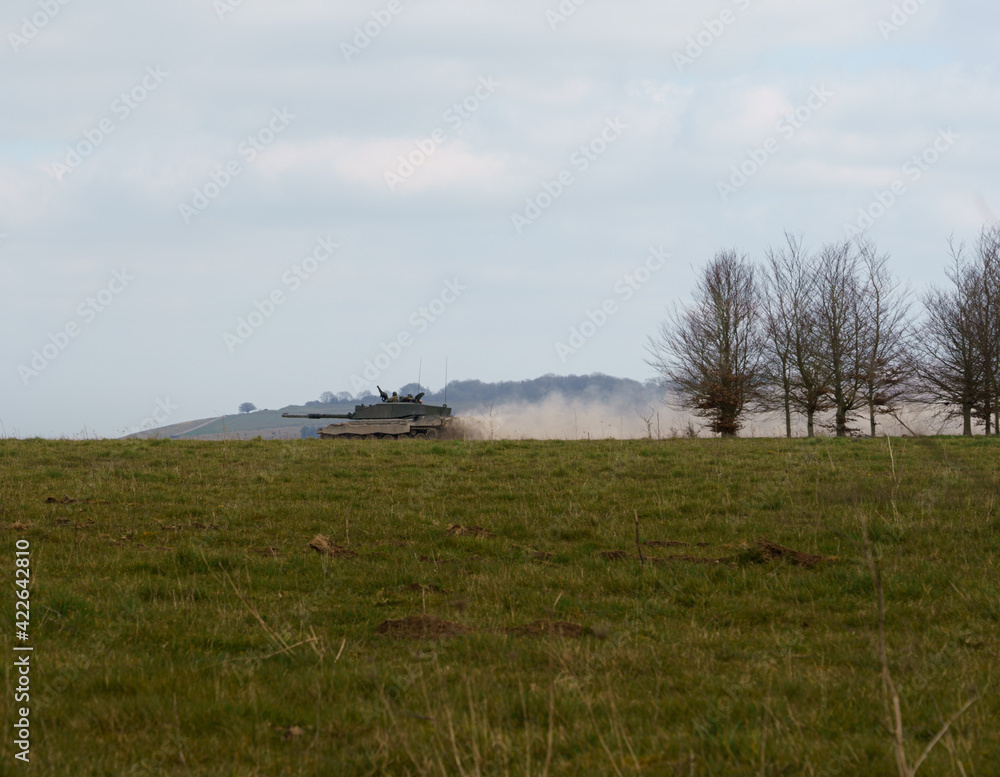 Challenger II main battle tank at full speed along a dusty stone track, on maneuvers in a demonstration of firepower, Salisbury Plain, Wiltshire