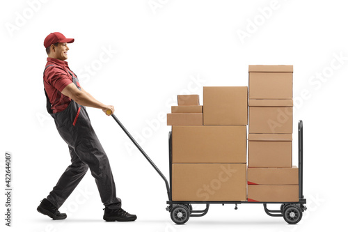 Worker pulling a hand truck loaded with cardboard boxes photo