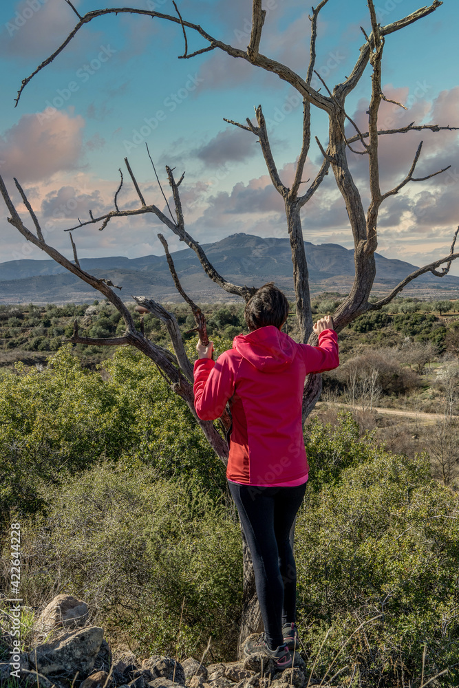 Happy woman enjoys the sunset views of the mountain, Spain.