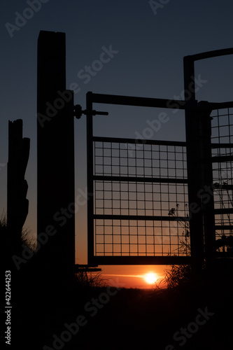 Silhouette of swing gate at sunset on Wales Coast Path Vale of Glamorgan and Glamorgan Heritage Coast Path