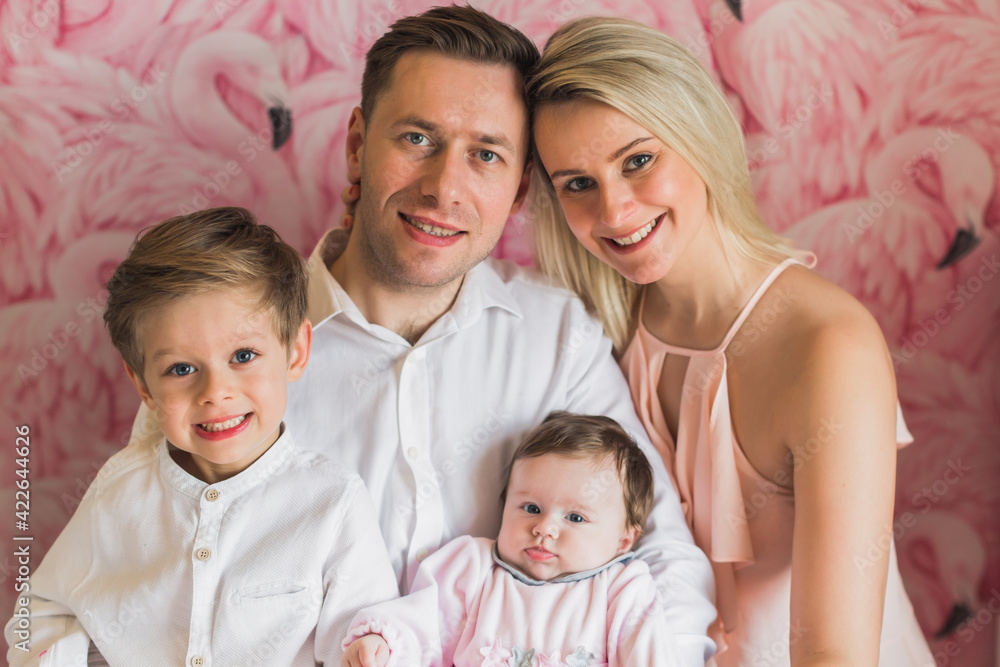 A happy family. Father, mother, son and baby daughter. Father holds children in his arms. Exemplary family. A happy family. Father, mother, son and baby daughter. Father holds children in his arms. Exemplary family.