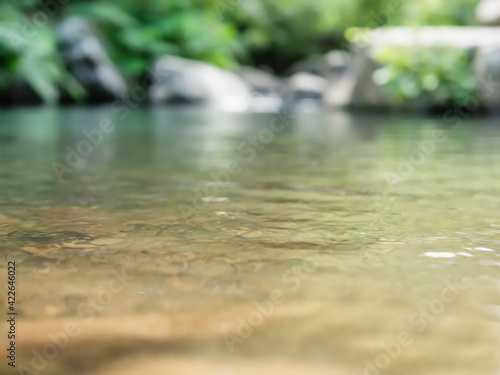 Abstract view of water surface of calm mountain stream with shallow depth of field