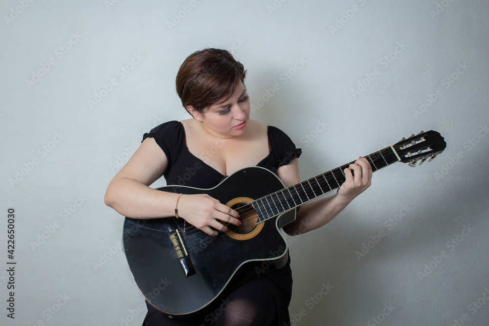 Fototapeta premium beautiful woman playing black spanish acoustic guitar