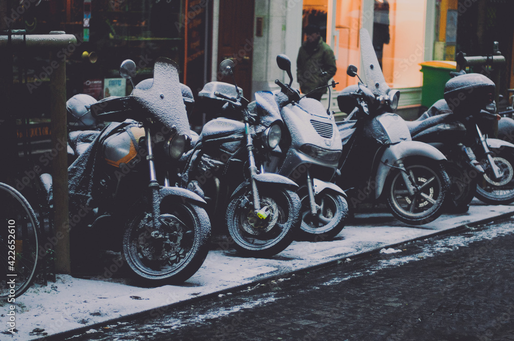 motos sur le trotoire recouvertes de neige