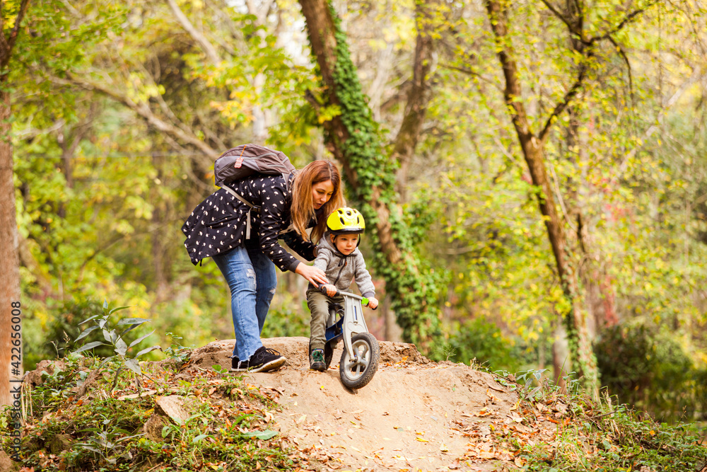 Supportive mom encourages boy to ride down the hill Supportive mom encourages boy to ride down the hill