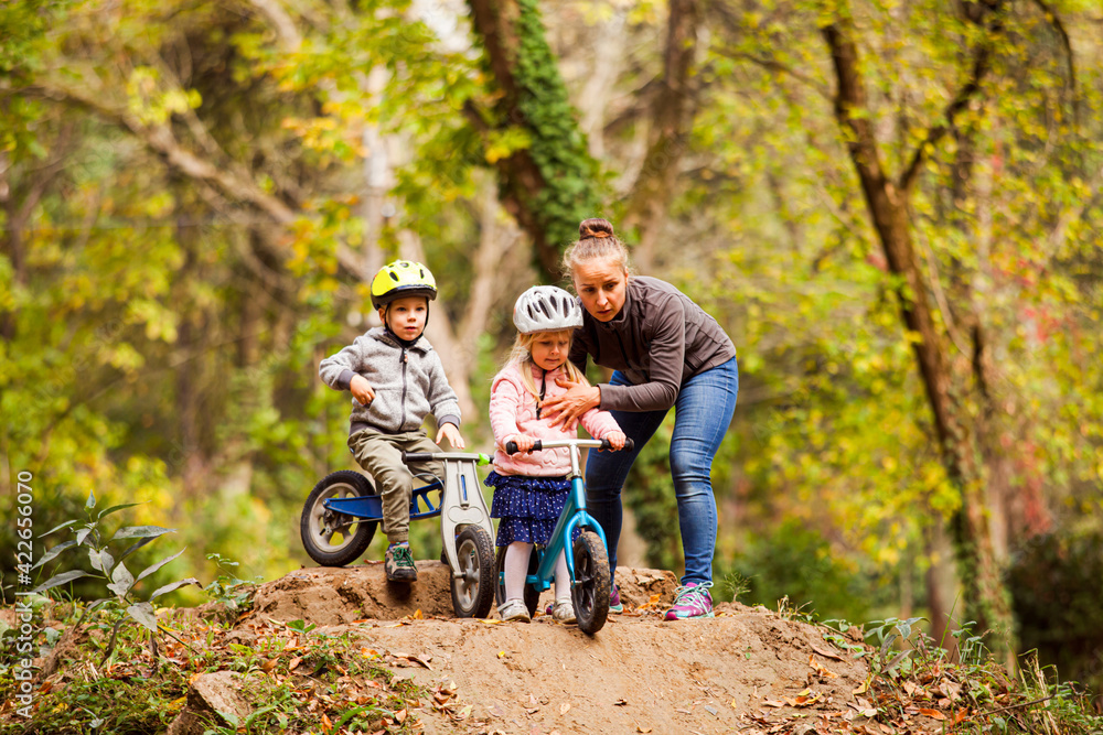 Supportive mom encourages boy to ride down the hill Supportive mom encourages boy to ride down the hill